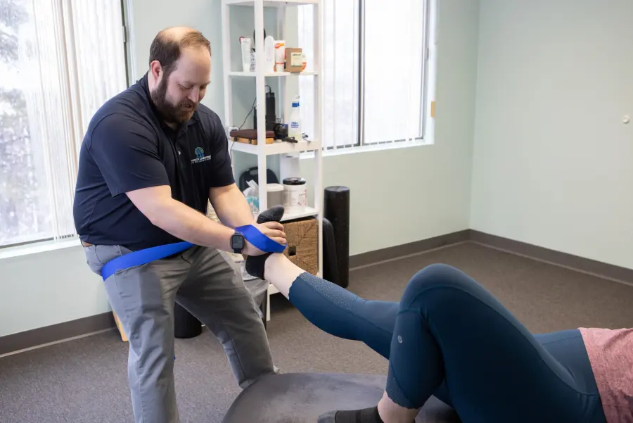 Dr. Scott guiding a leg stretch with a strap